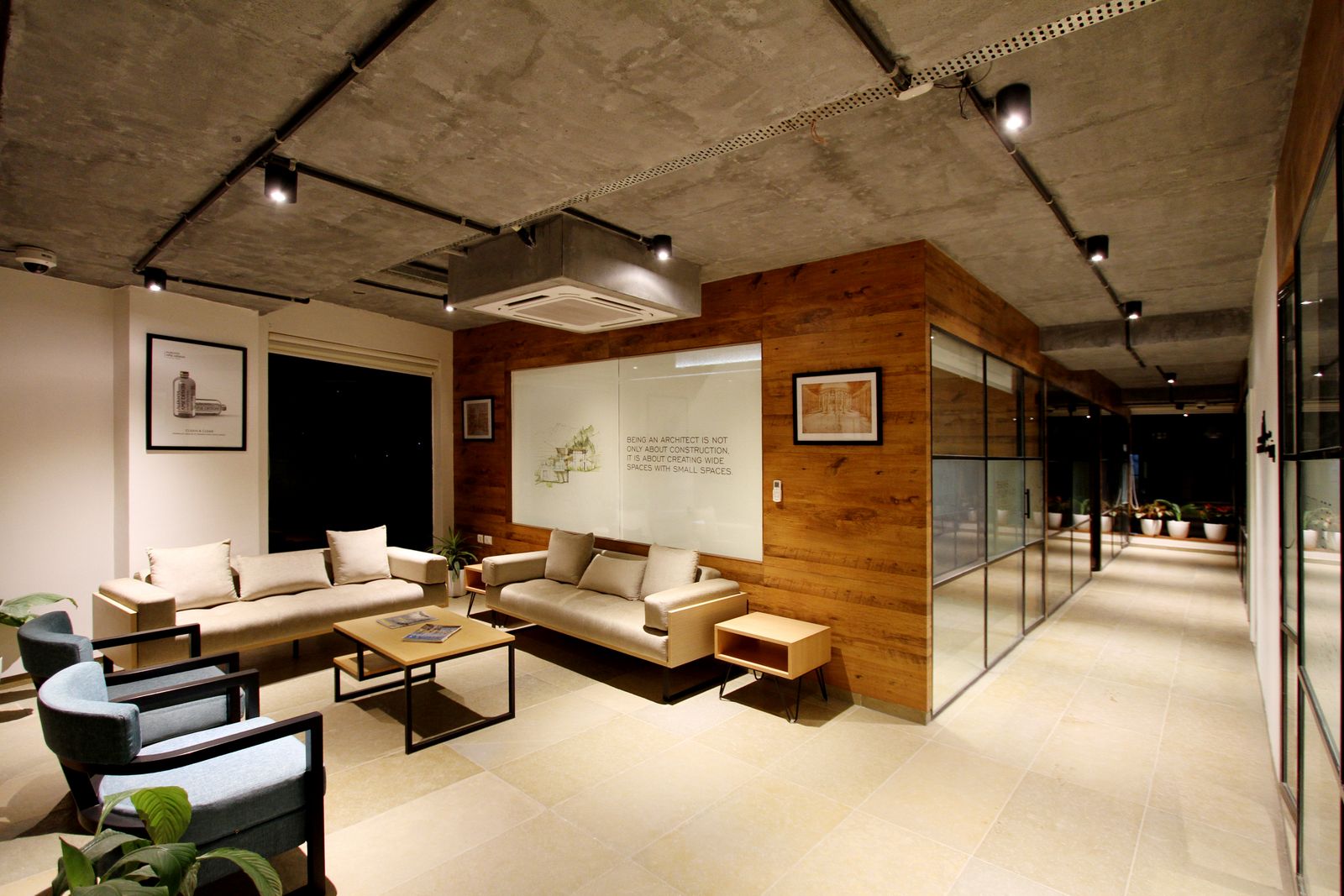 Breakout lounge with exposed concrete ceiling and timber panelling