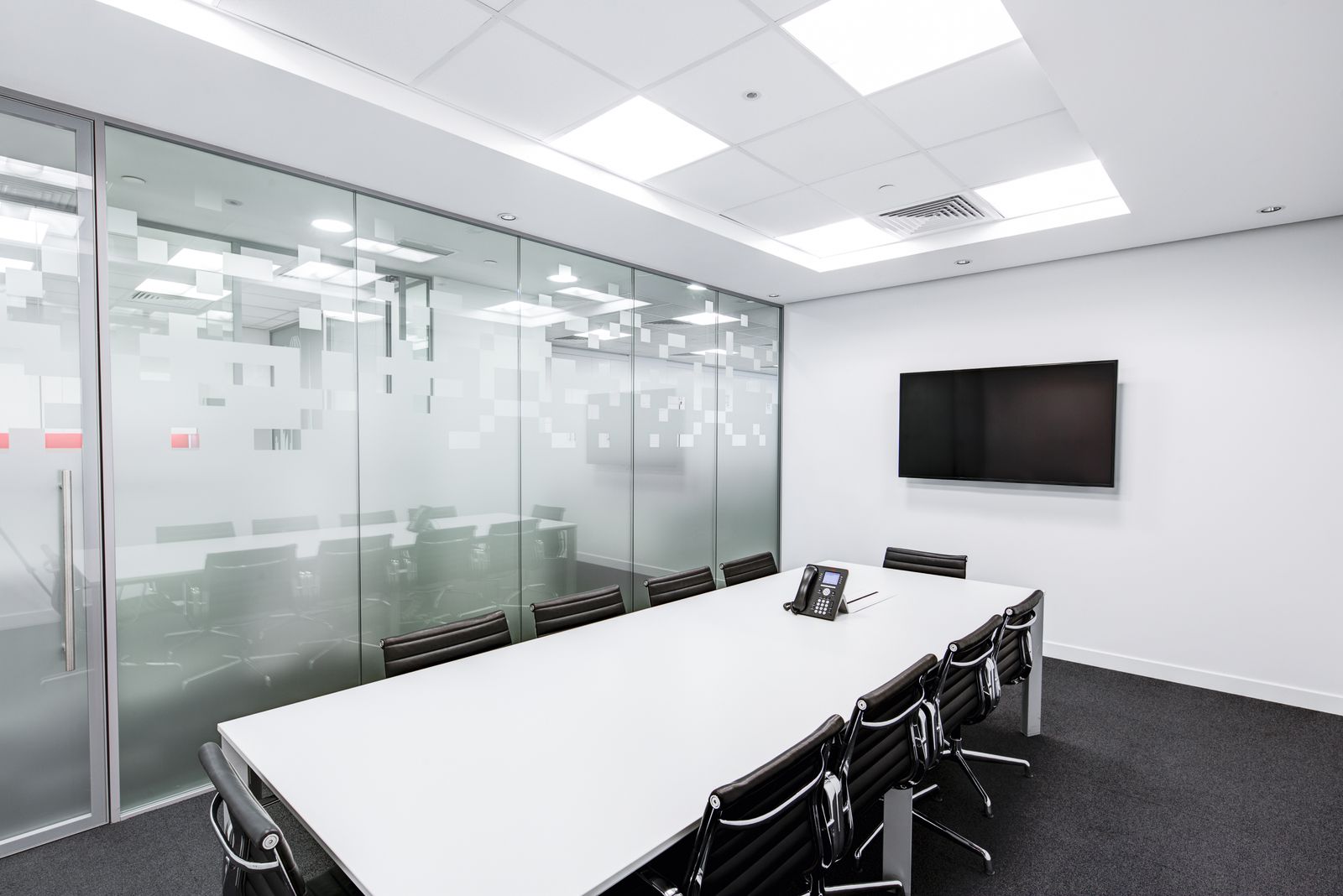 White boardroom with glass partition and manifestation film