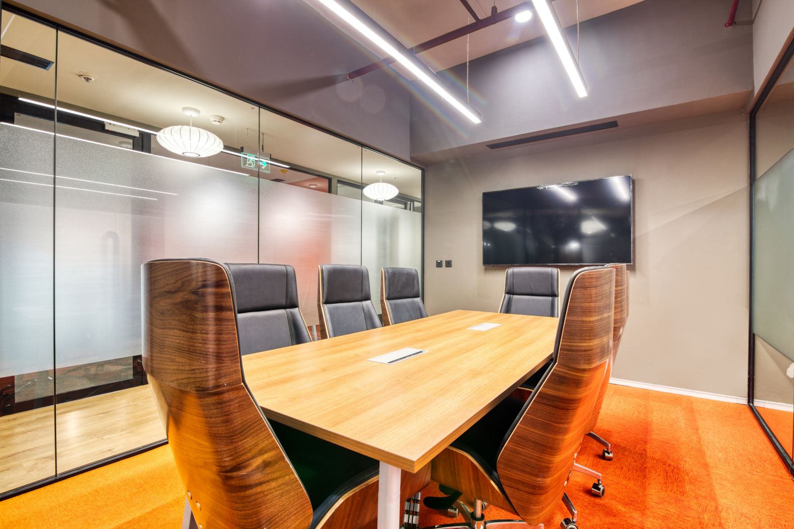 Executive boardroom with walnut chairs and orange carpet