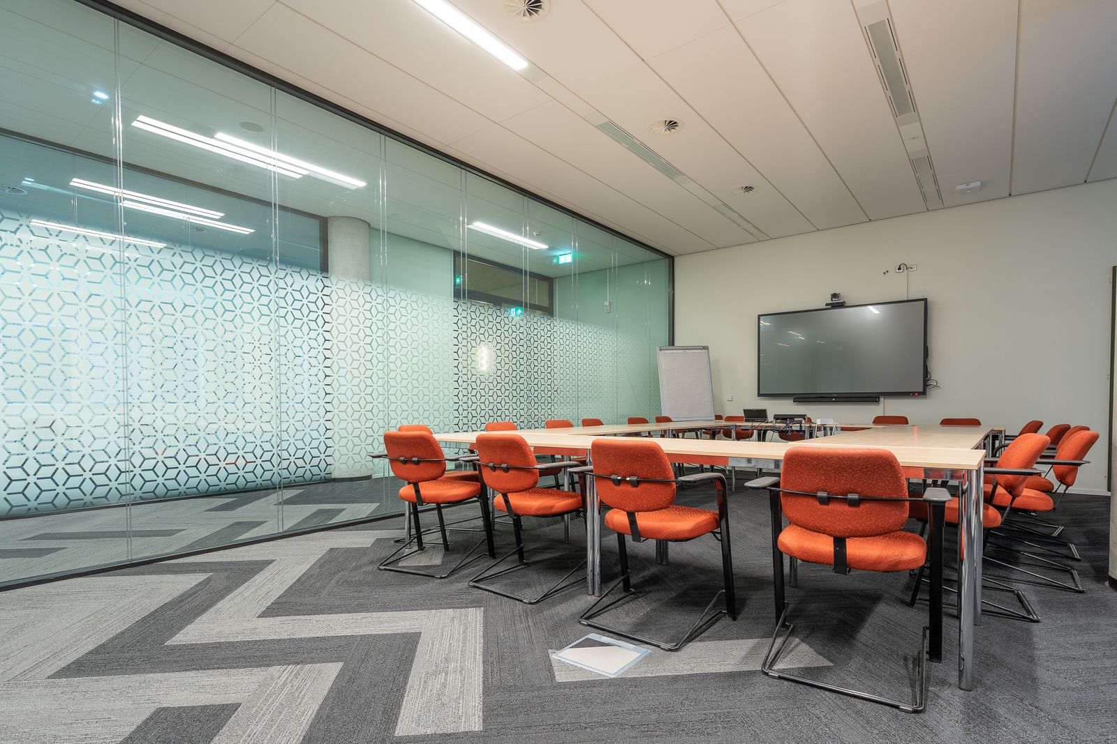 Training room with patterned glass wall and orange seating