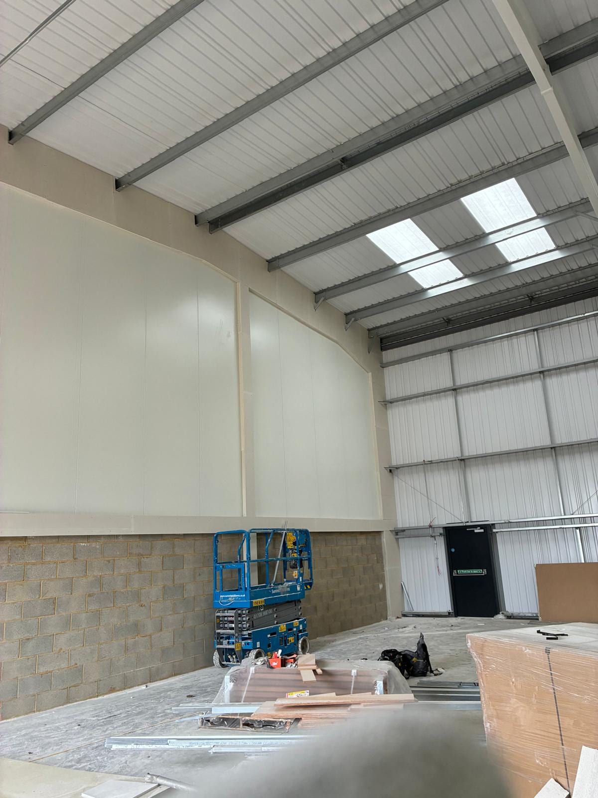Warehouse unit with white wall lining fixed above the blockwork