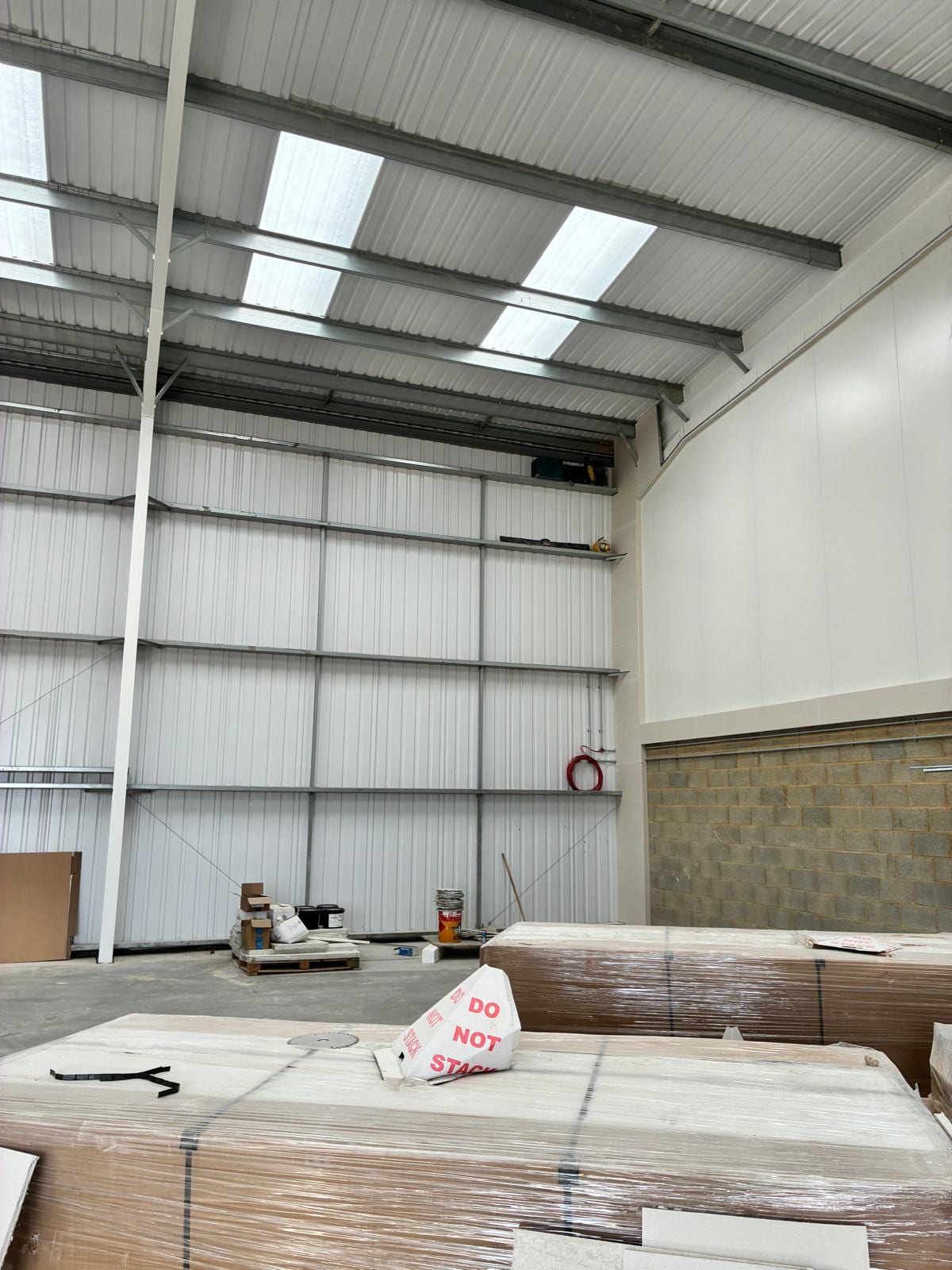 Steel portal frame warehouse with wall lining in place and rooflights above