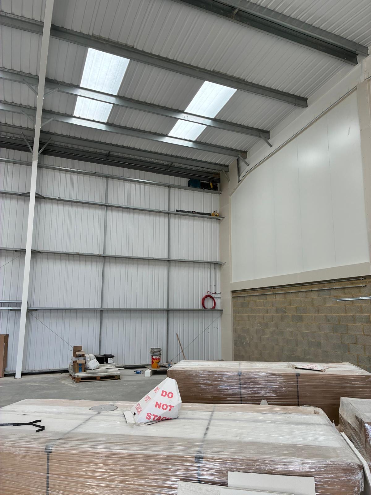 Warehouse interior with the wall lining complete and materials on pallets
