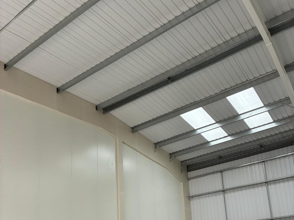 Warehouse unit with white wall lining fixed above the blockwork