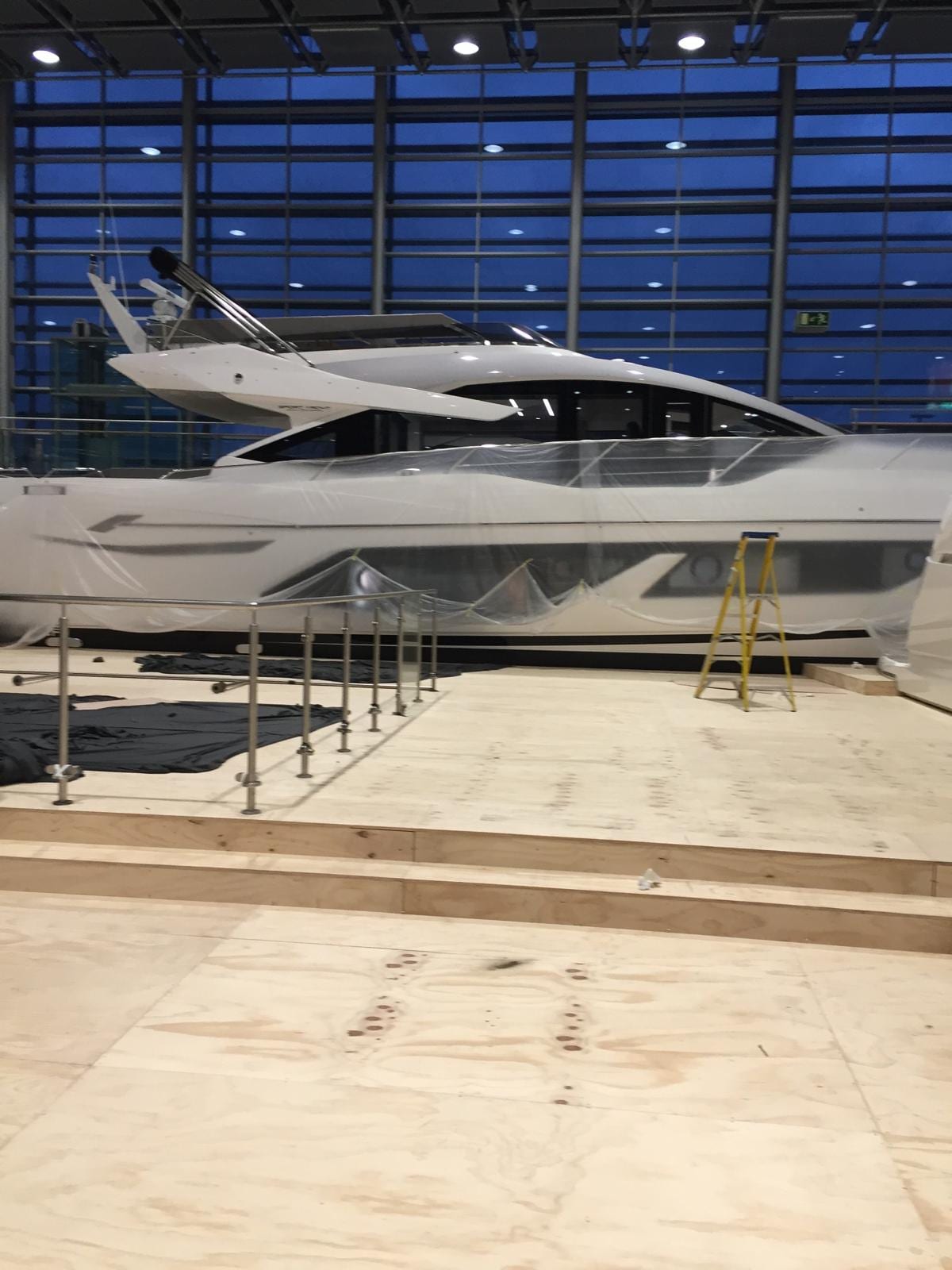 Sunseeker motor yacht on the plywood display deck under the exhibition hall glazing