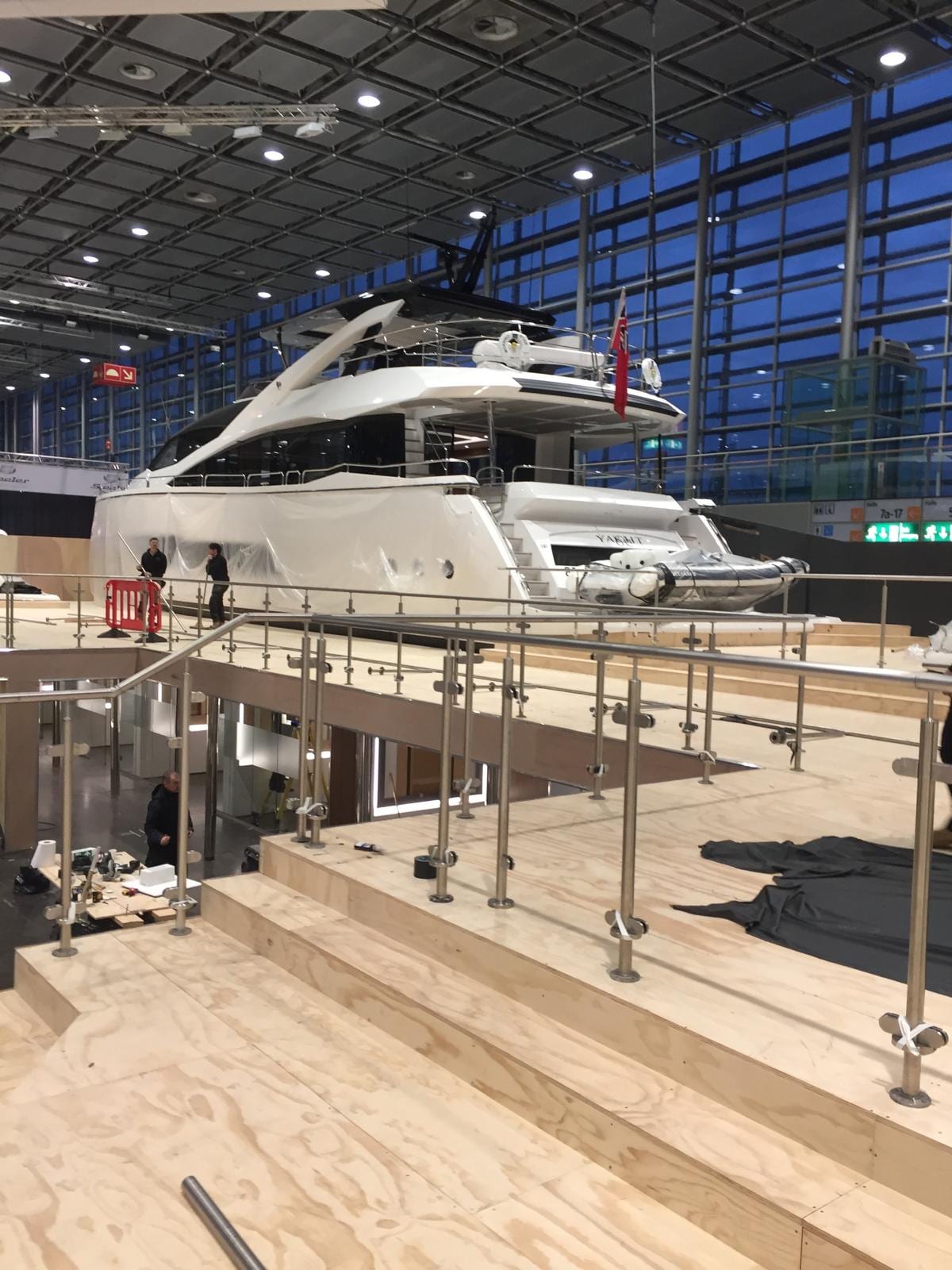 Motor yacht on the show stand with a stainless steel balustrade to the walkway
