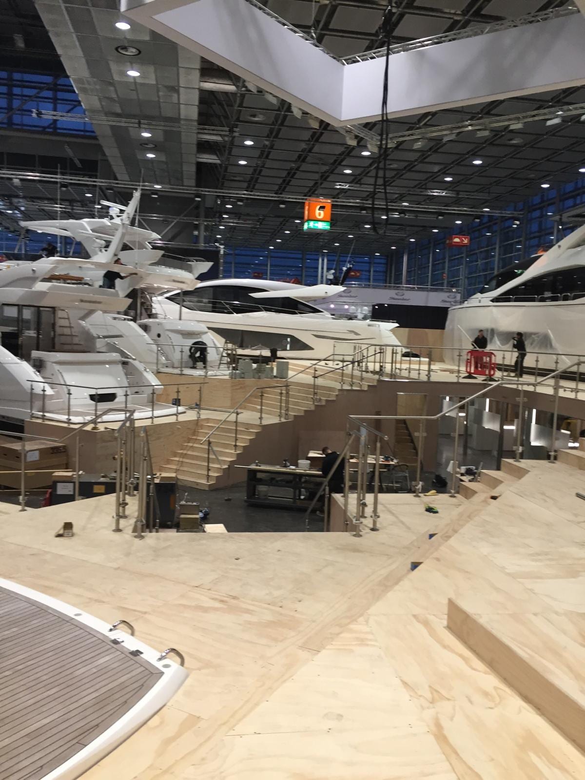 Show stand decking and balustrade running between the display yachts