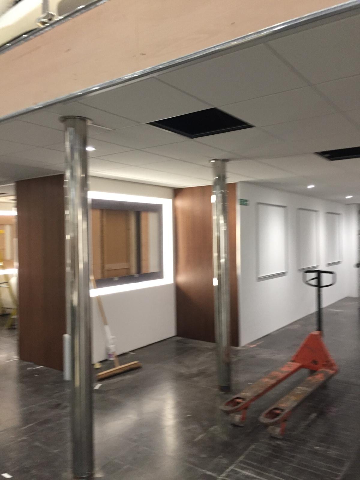 Stainless columns and dark timber panelling with a pallet truck on the stand floor