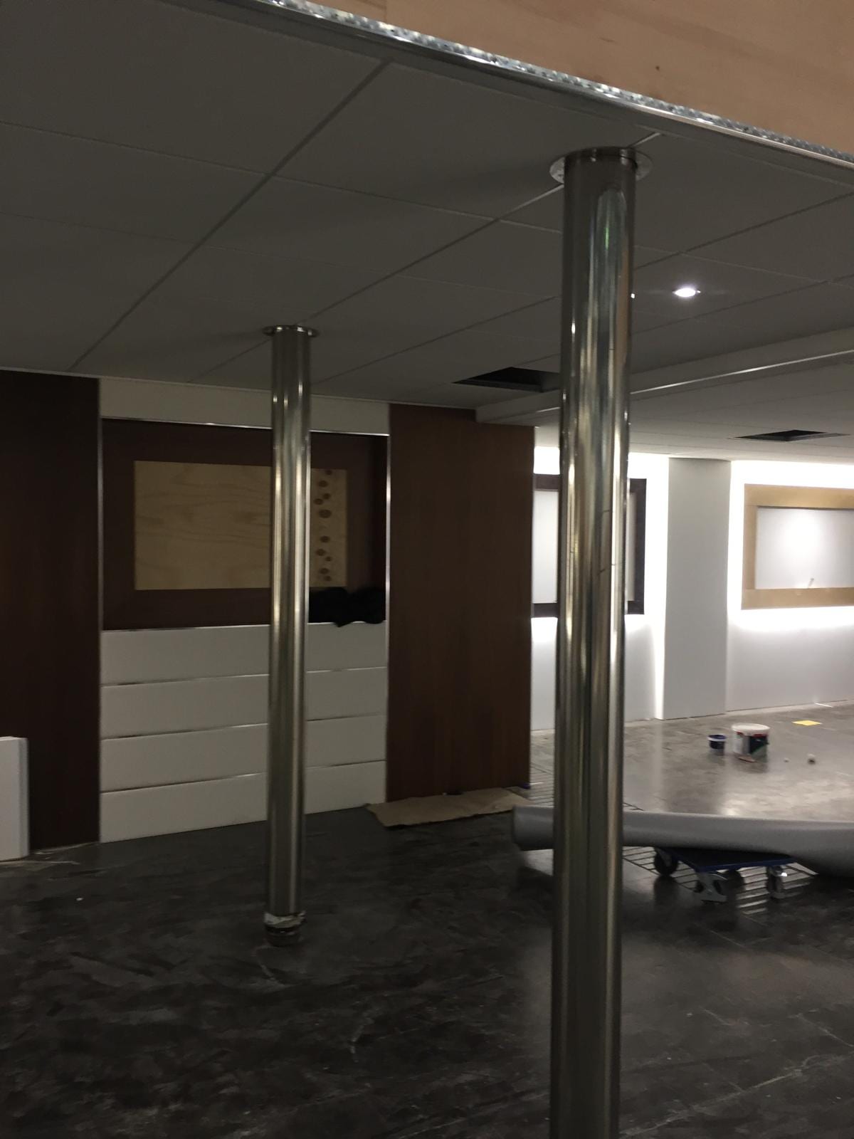 Dark timber panelled walls and stainless columns in the stand interior