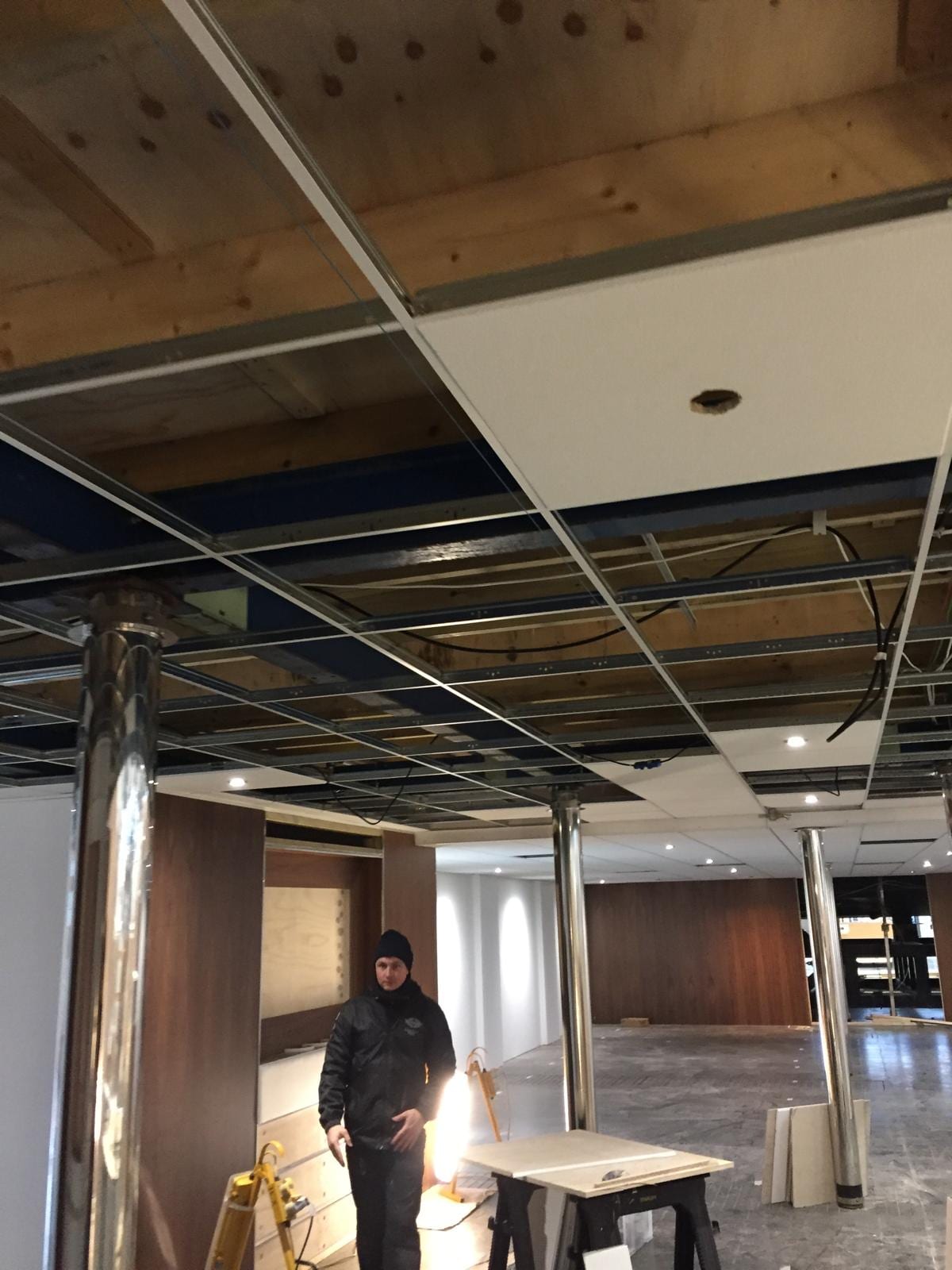 Ceiling grid across the stand with materials stacked below