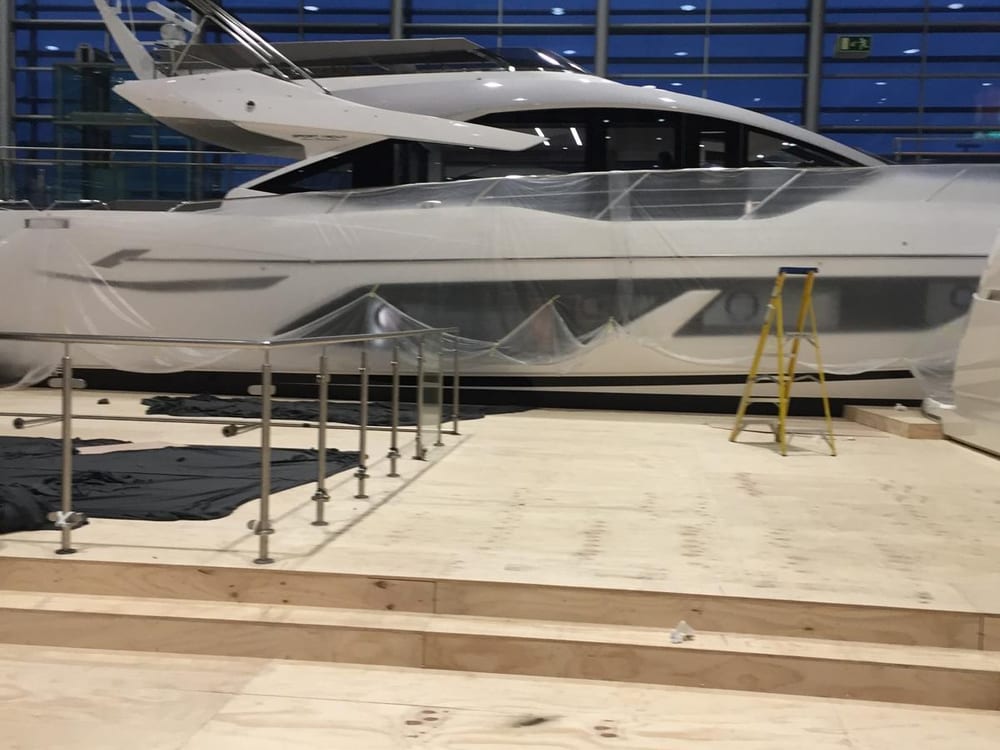Sunseeker motor yacht on the plywood display deck under the exhibition hall glazing
