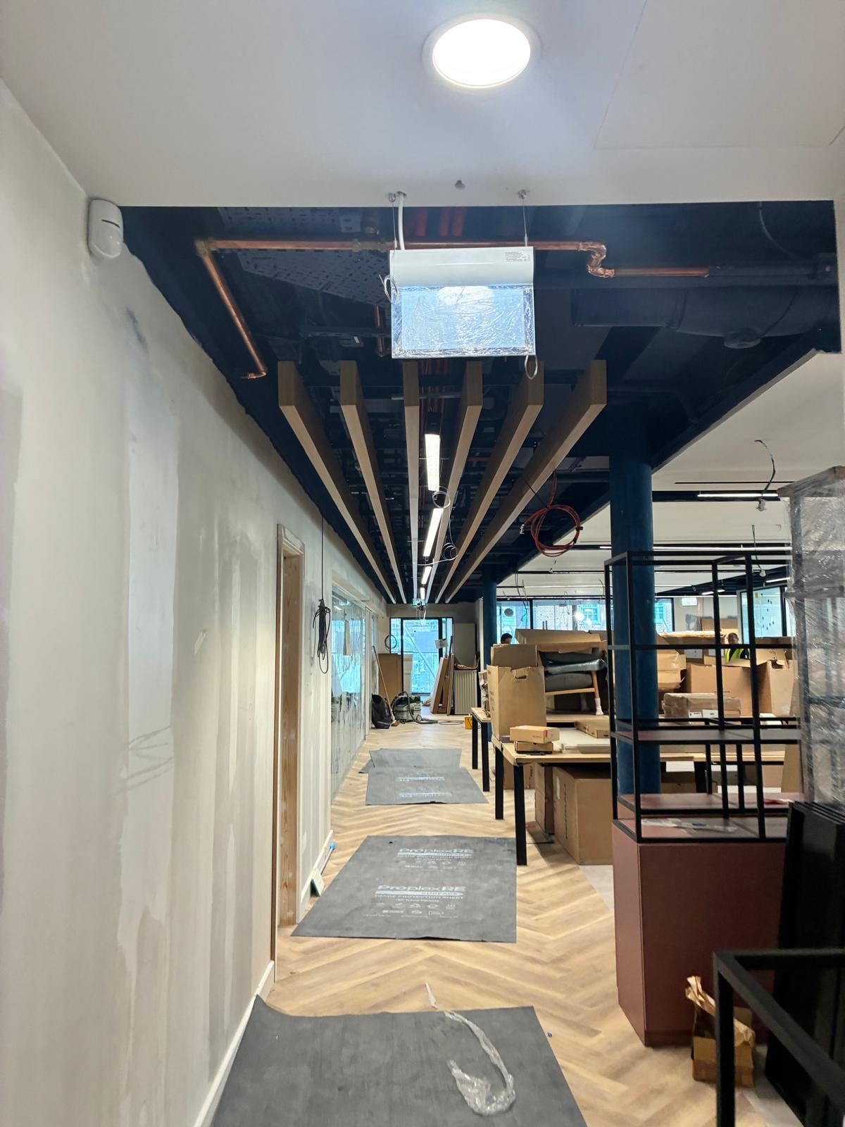 Timber baffle ceiling and dark painted soffit above a herringbone floor