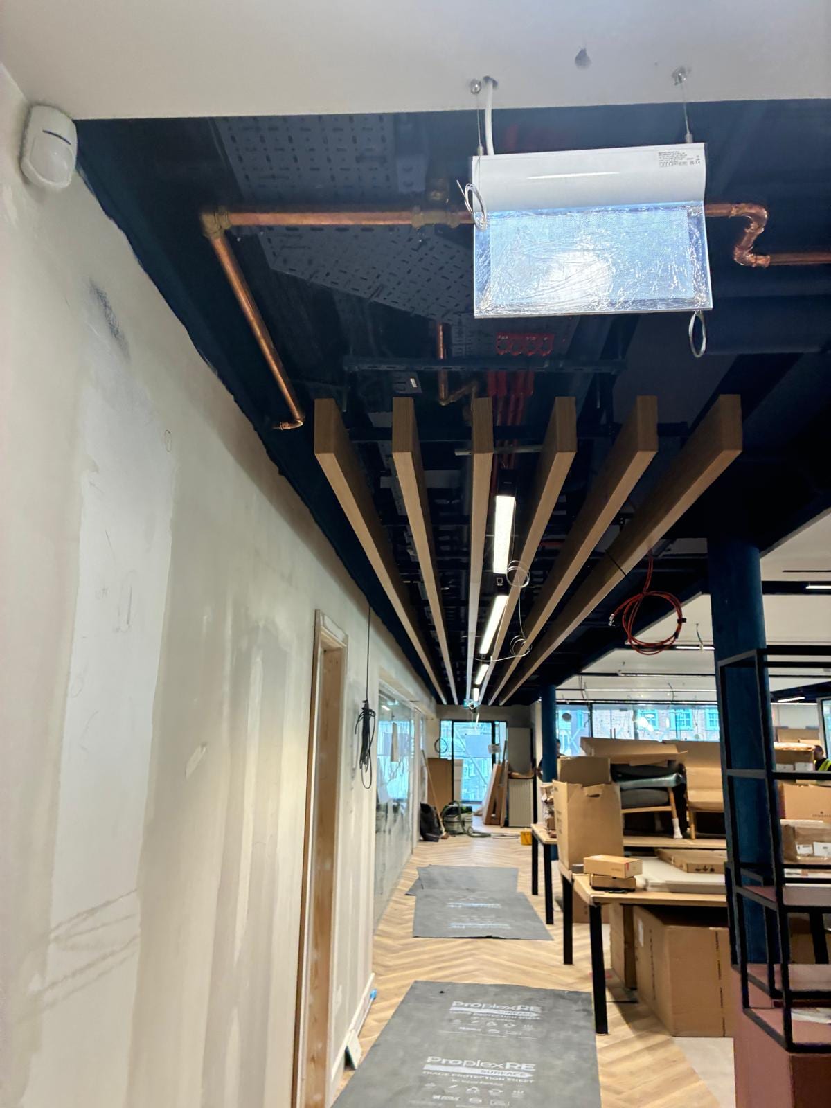 Timber baffles fanning out from the corner above the shop floor
