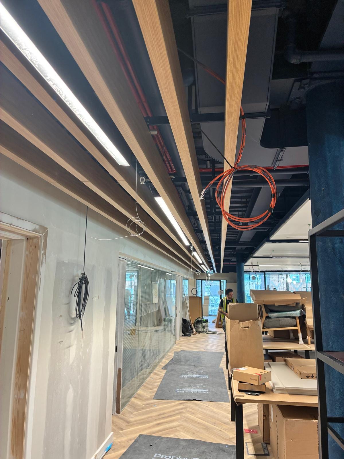 Timber baffle ceiling over the walkway with display units being built below
