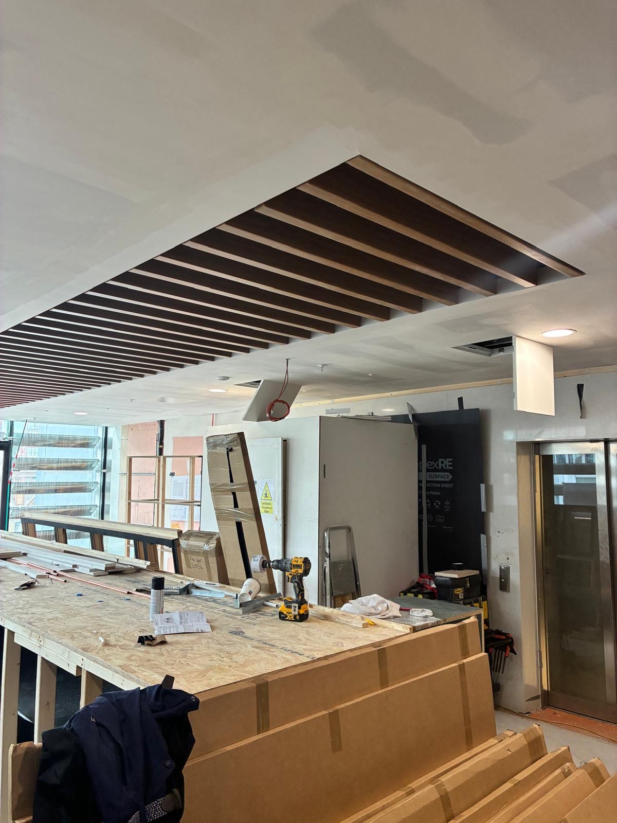Counter build and timber baffles with the lift lobby beyond