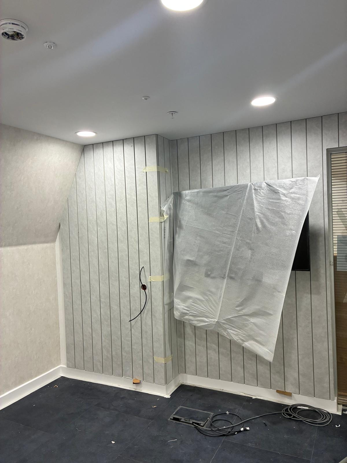 Meeting room with grey slatted acoustic wall panelling and a screen bracket