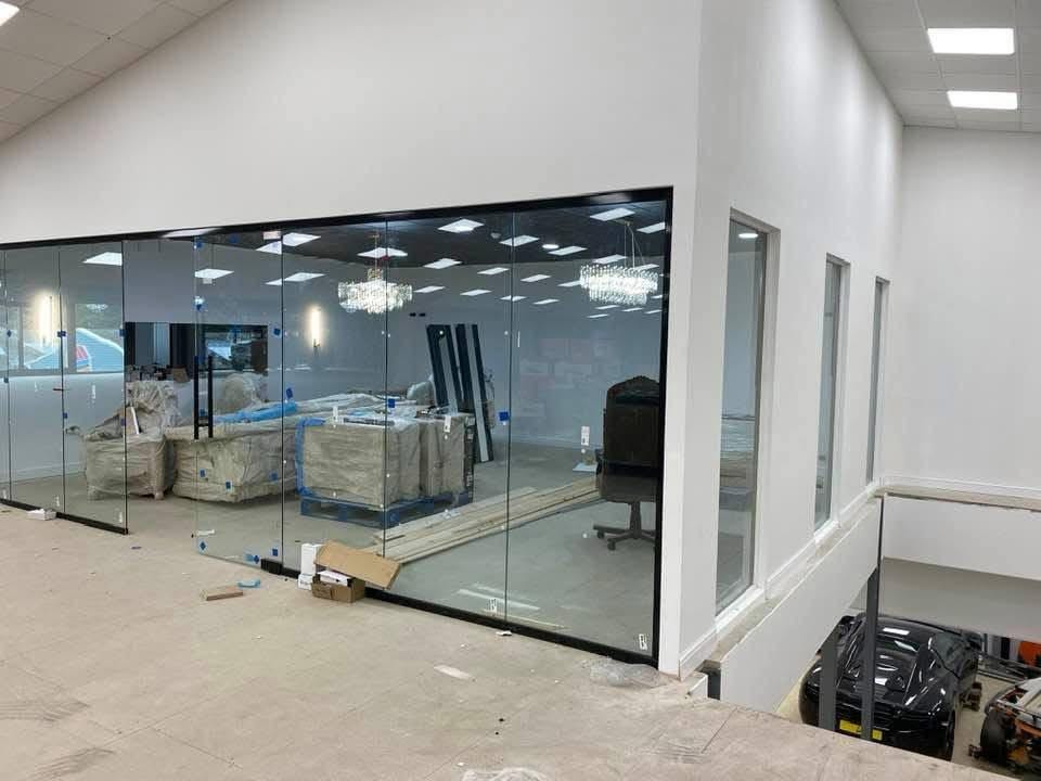 Frameless glass partition offices overlooking the showroom floor