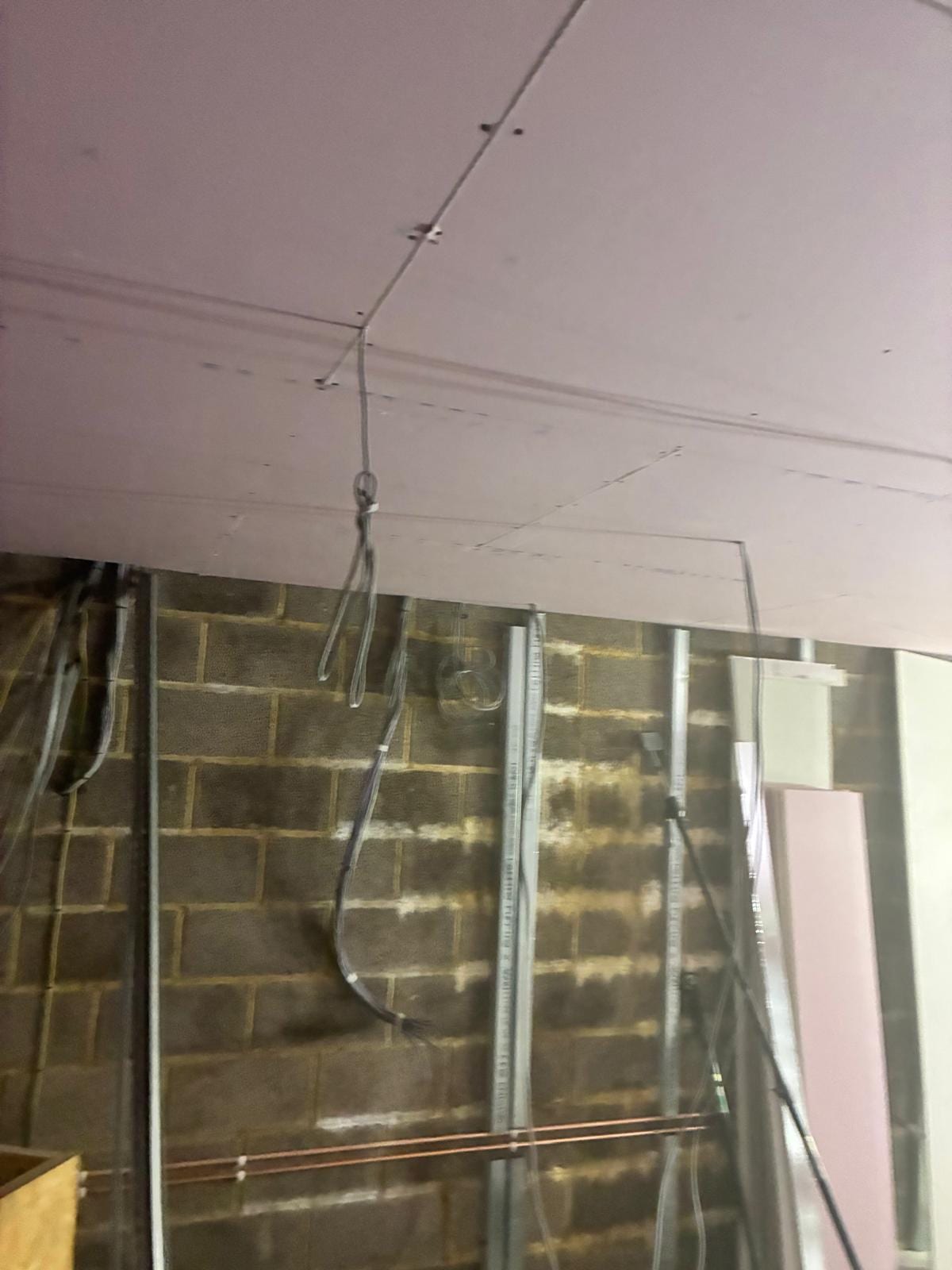 Metal studwork and services run against the blockwork wall